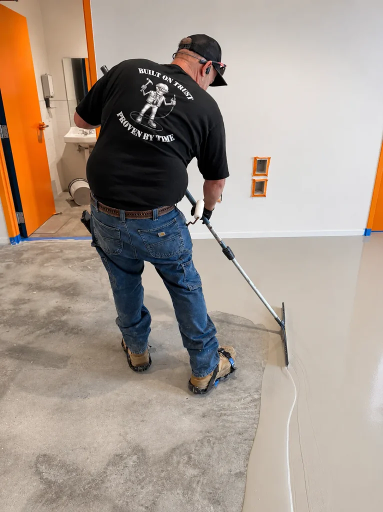 Crew member spreading the epoxy base layer with a squeegee