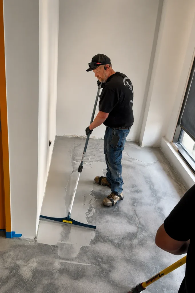 Colored epoxy base layer going down across the floor